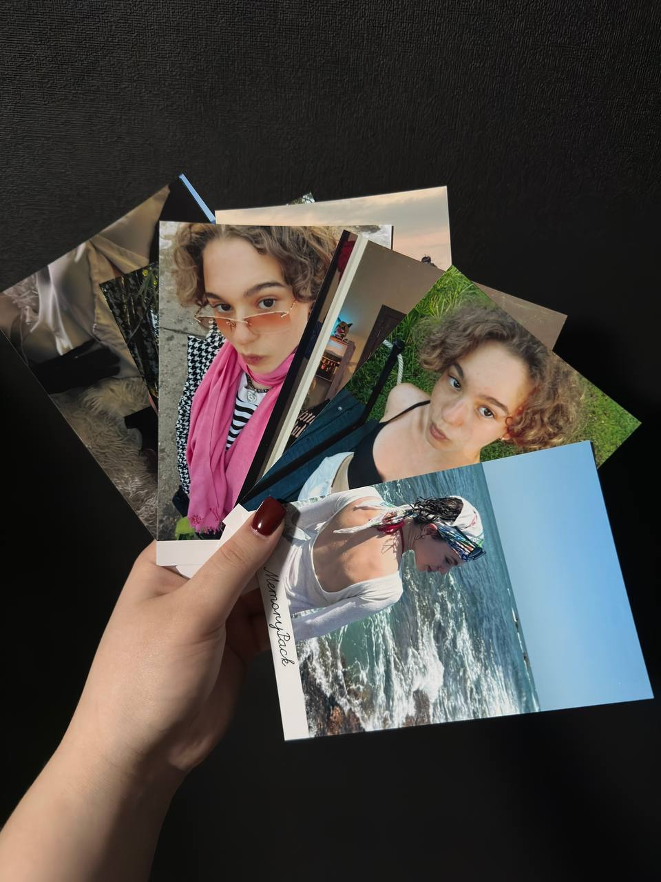 Пачка напечатанных фотографий в руке